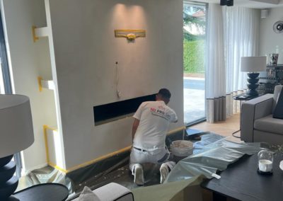 Professionnel ND Pro Sàrl appliquant méticuleusement une nouvelle couche de peinture pour rénovation d'intérieur.